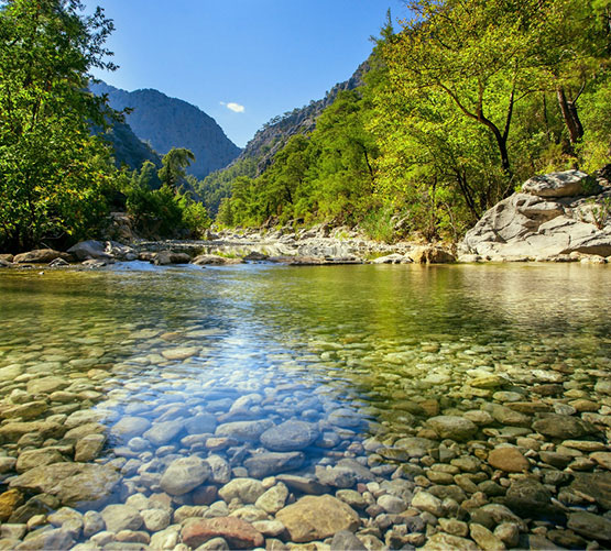 Een rivierstroom in de bergen die een influentwaterbron vertegenwoordigt.